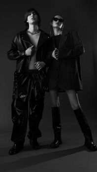 Edgy black and white studio shoot featuring modern fashion with leather and sunglasses.