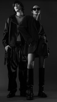 Stylish black and white fashion portrait featuring models posing in edgy outfits.