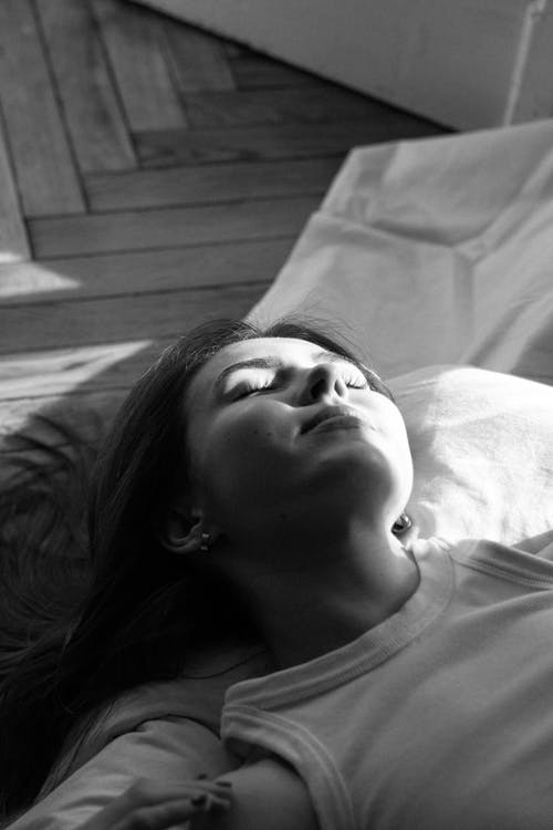 A woman laying on a bed with her eyes closed