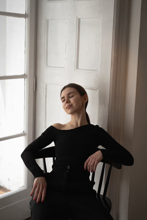 A woman in black sitting on a chair