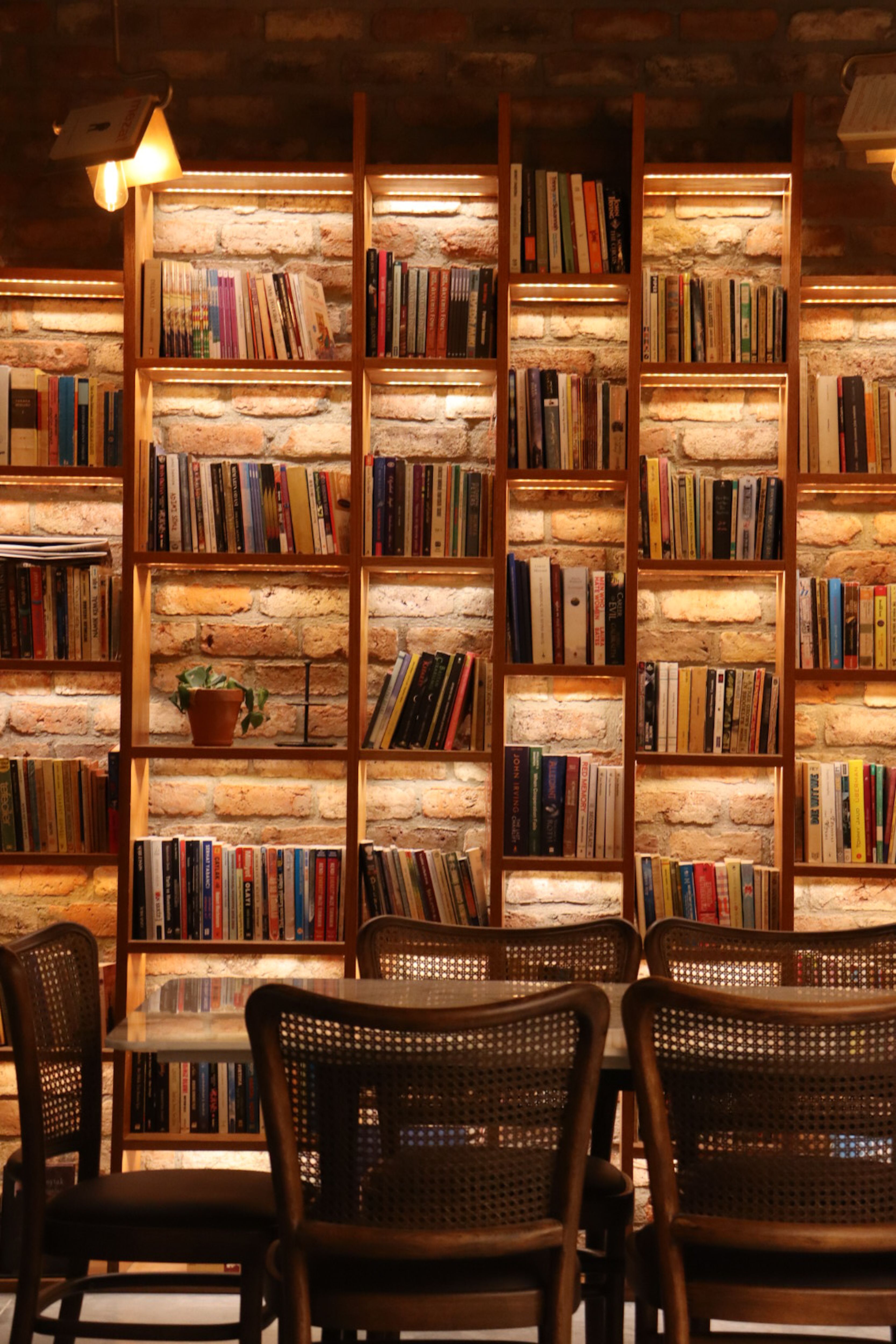 Warmly lit library with bookshelves and chairs, perfect for reading and study.