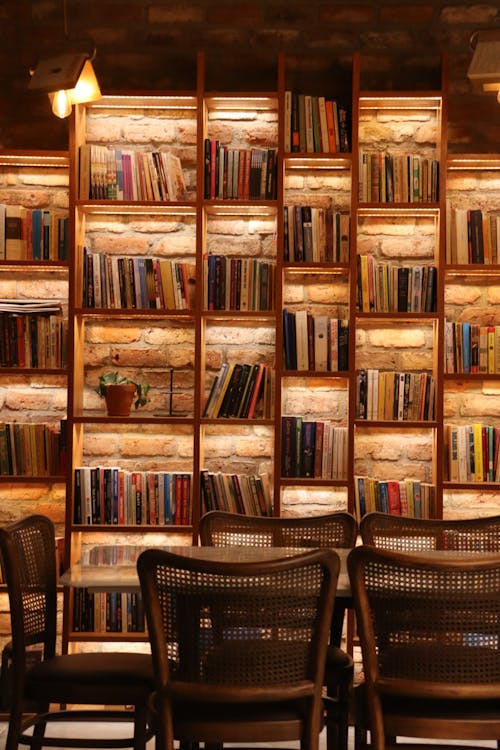 A room with a large book shelf and chairs