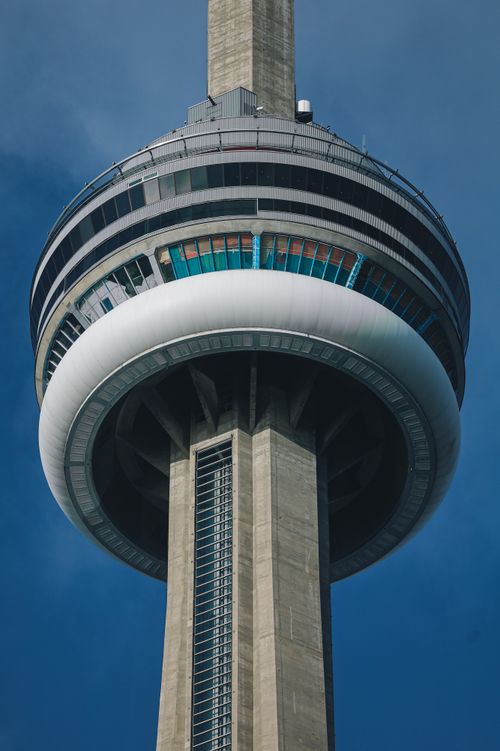 Free A striking view of Toronto's CN Tower showcasing modern architecture against a blue sky. Stock Photo