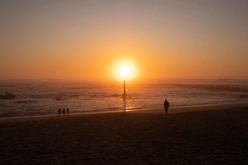 Sun Setting Over the Lighthouse by the Beach