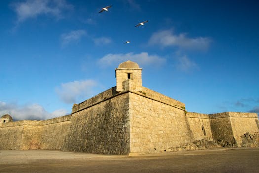 Fort São João Baptista in Vila do Conde, Portugal with birds soaring in the blue sky.