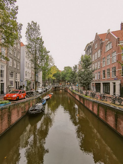 A canal with boats and buildings in the background