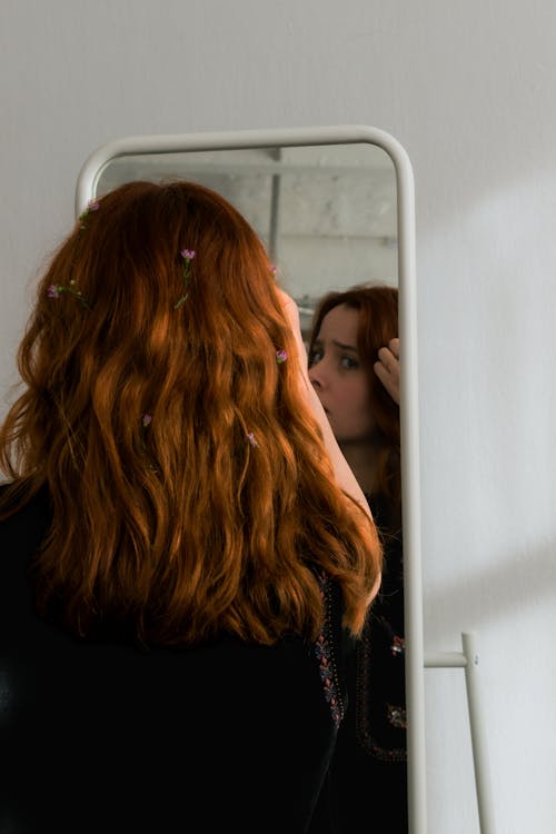  Young Woman with Flowers in Her Hair Looking in the Mirror