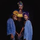 三位非洲妇女的迷人肖像中，她们头戴彩色头巾和牛仔布，脸上涂着彩绘