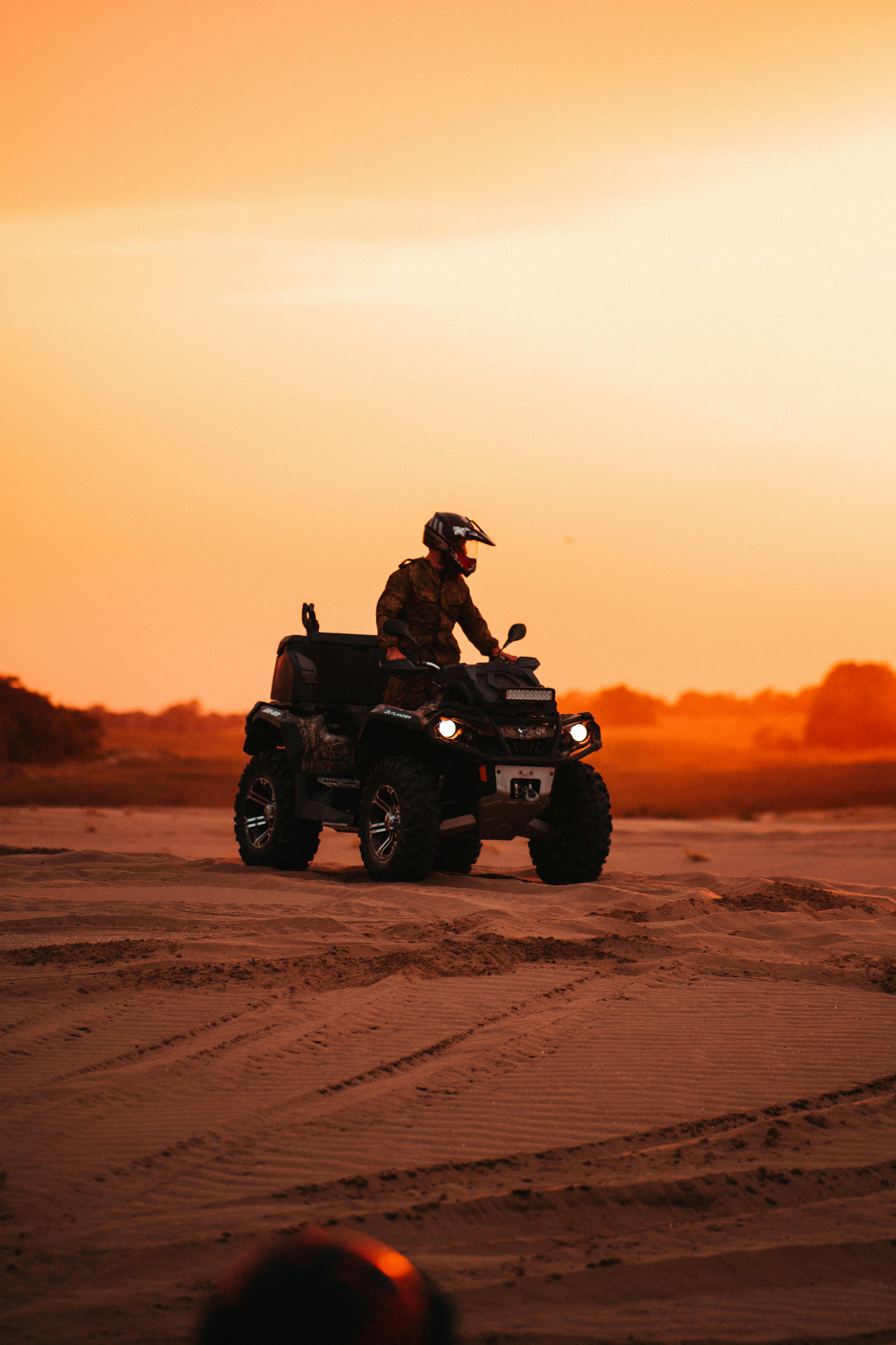 A thrilling ATV ride across the desert landscape during a vibrant sunset.