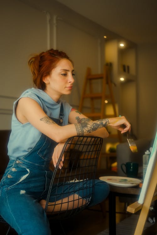 Woman with Tattoos Sitting with Paintbrush