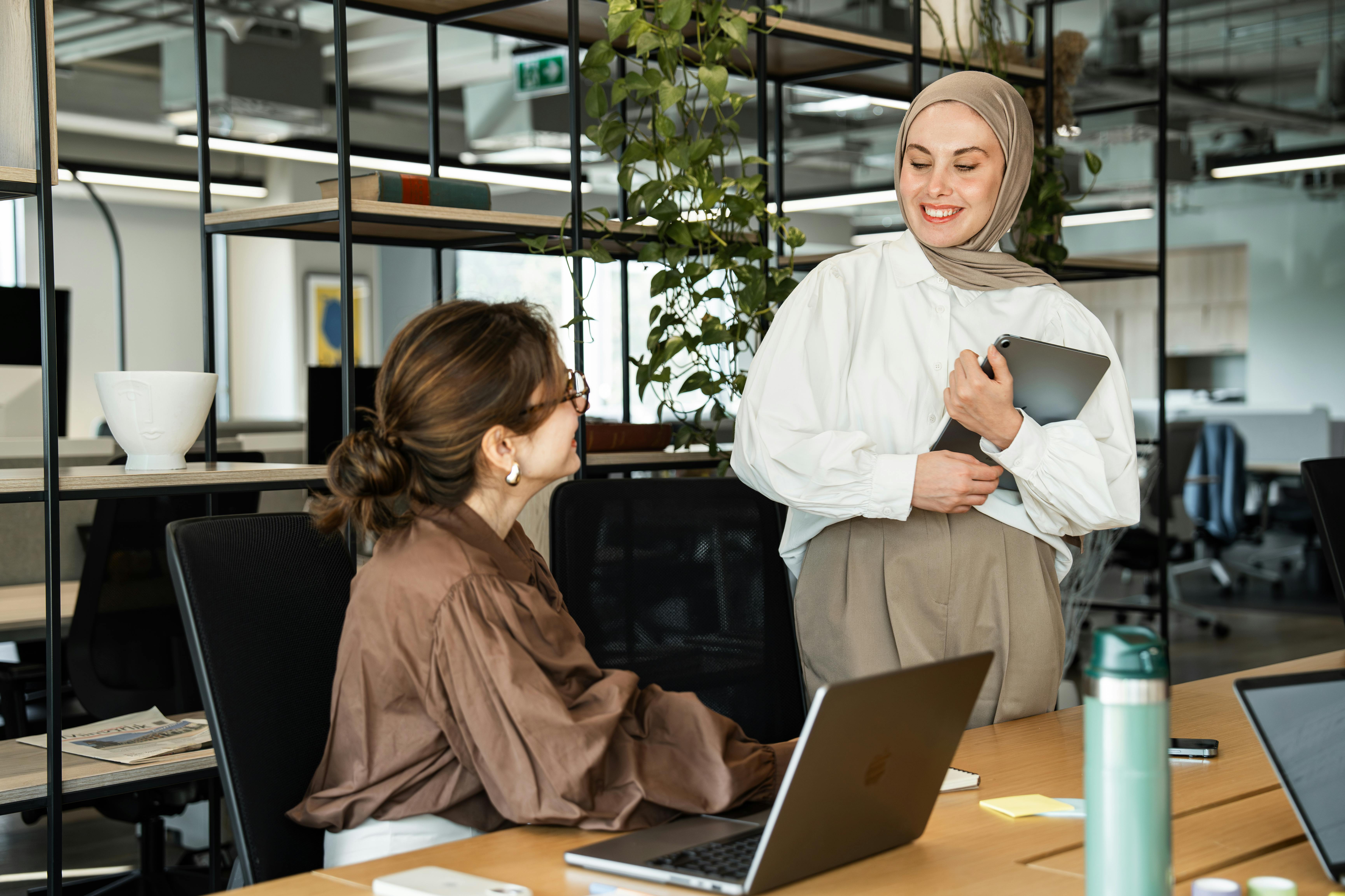 photo of two women in an office with shelves