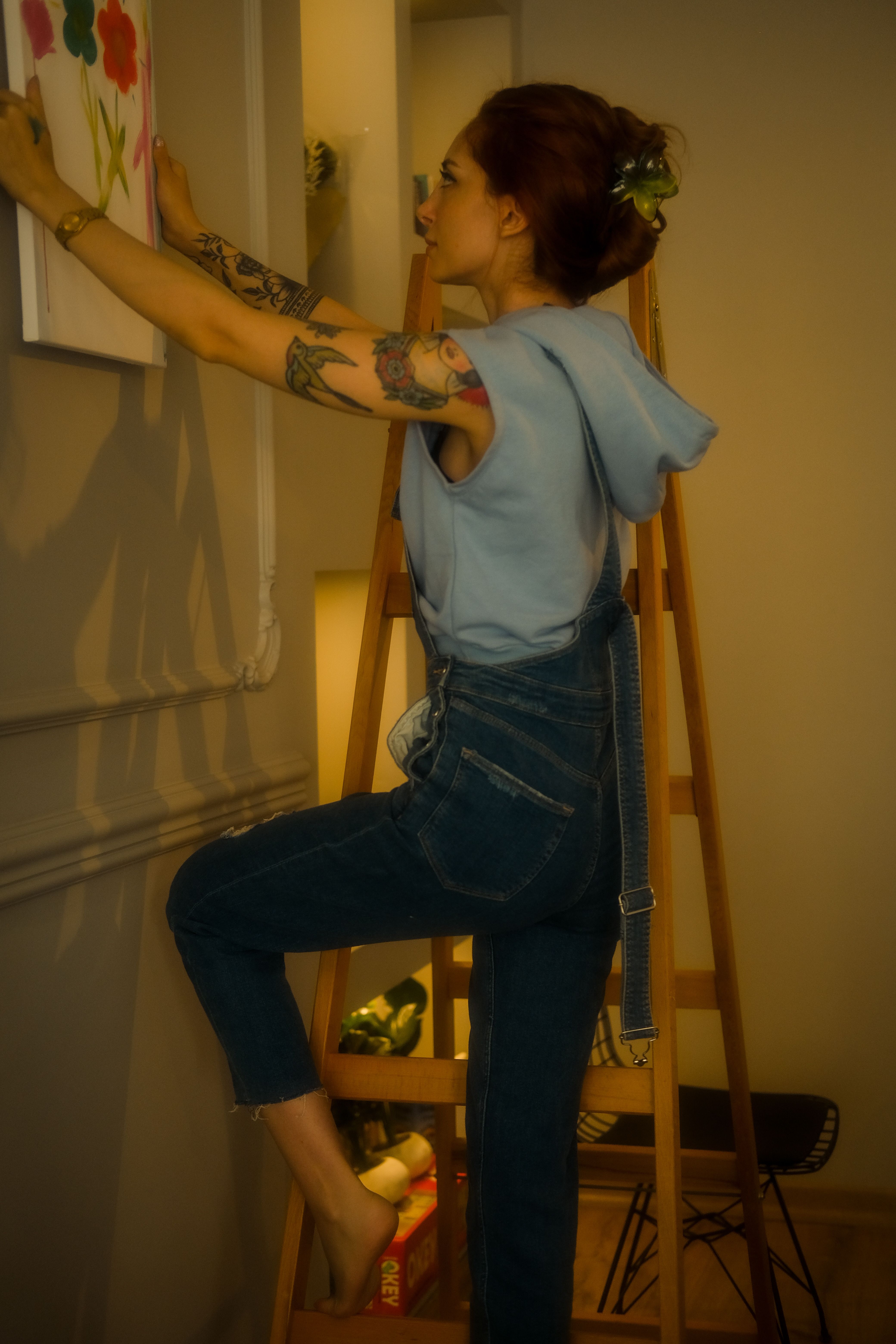 person hanging wallpaper ladder wall