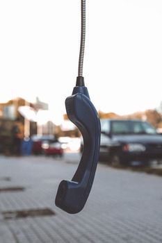 A classic telephone handset suspended in an urban setting, conveying vintage nostalgia.