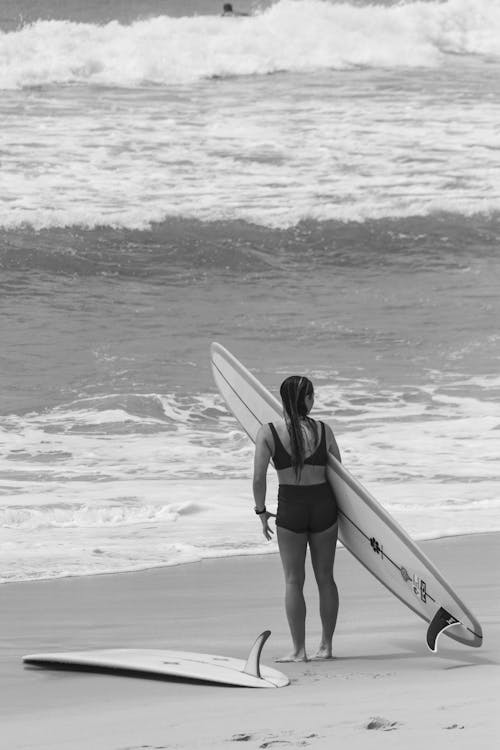 Back View of Woman with Surfboard on Beach