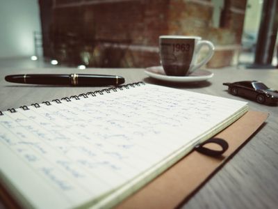 Handwritten notes and a coffee cup on a warm wooden desk, photo by David Bares on Pexels