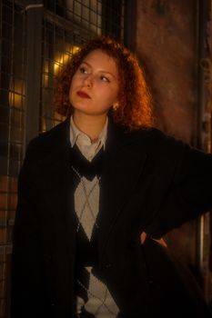 Fashion portrait of a redhead woman in a stylish blazer posing with a thoughtful look inside.
