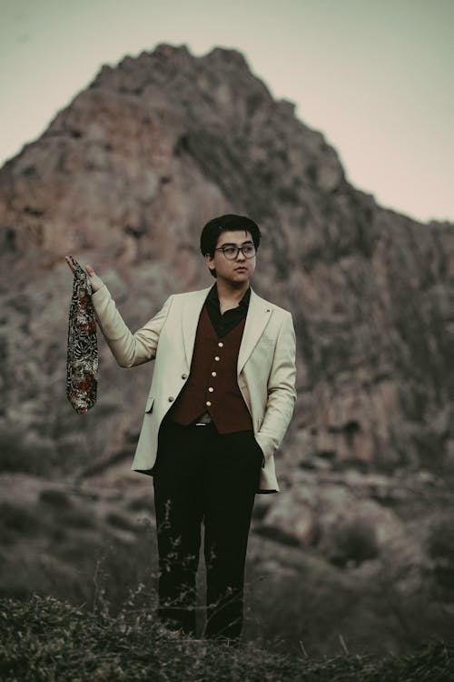 Man Standing in White Suit and Holding Shawl