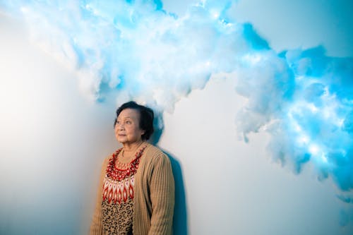 A woman standing in front of a wall with clouds