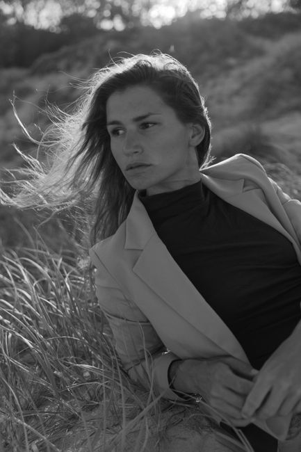 Stylish black and white portrait of a woman in nature, evoking elegance and grace.