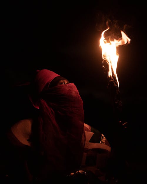 Free Person in Hat and Shawl and with Torch at Night Stock Photo