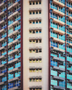Close-up view of a modern high-rise building facade featuring rows of glass windows and balconies.