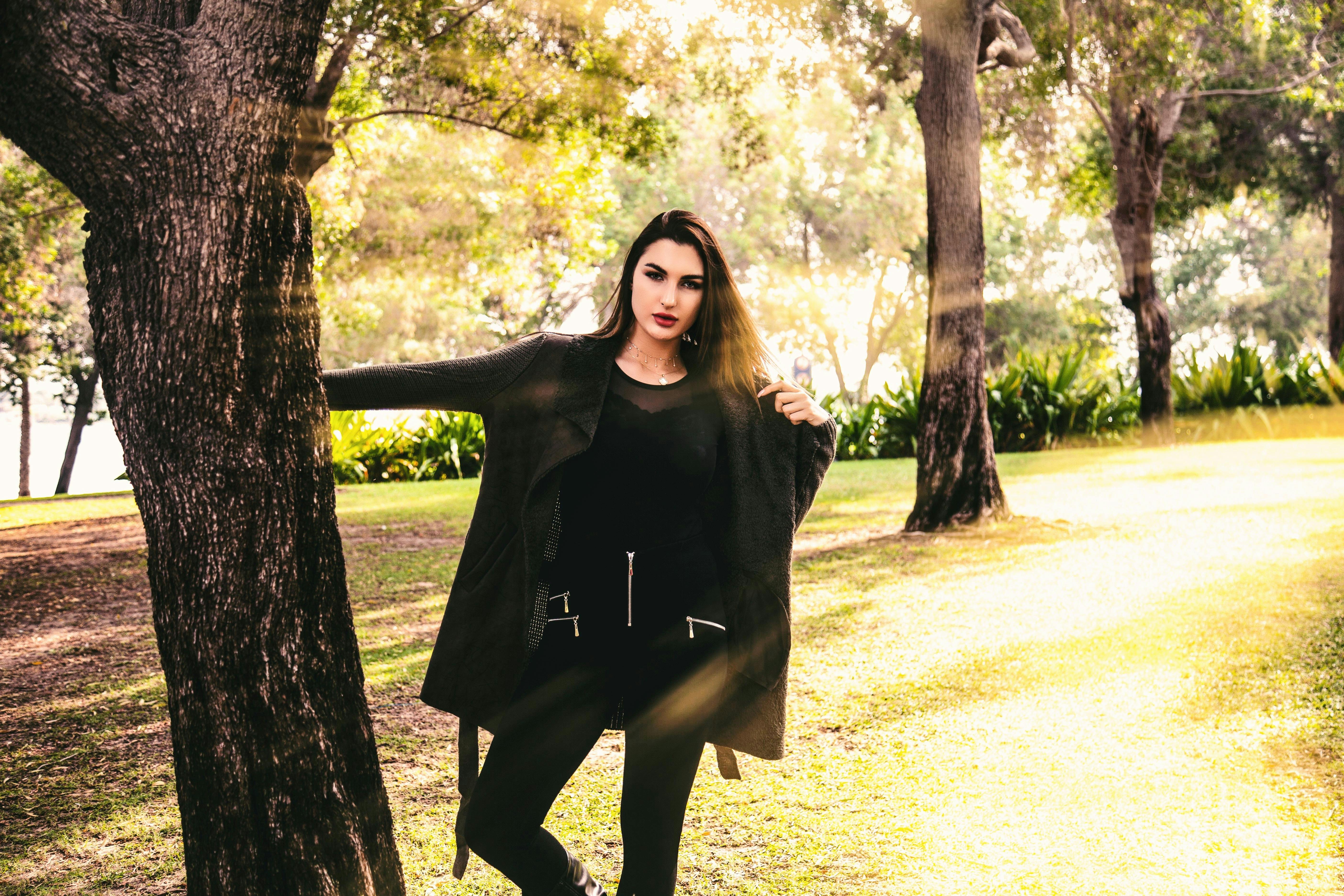 woman standing near tree trunk