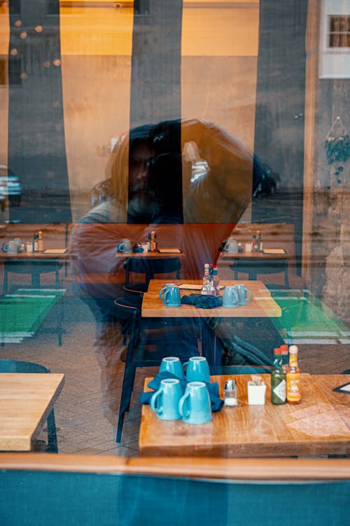 A reflection of a person in a restaurant window