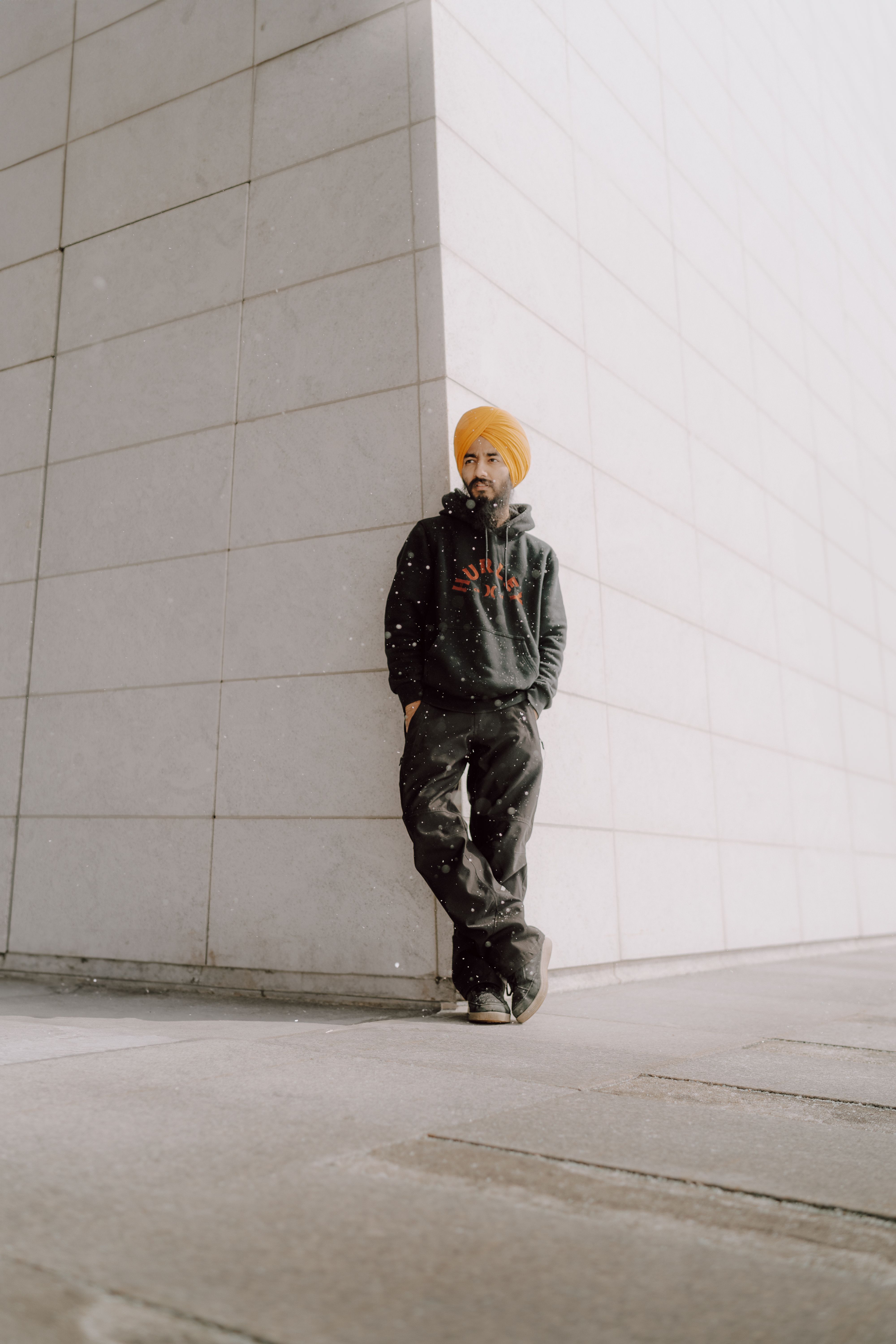 A man in a yellow turban leaning against a wall · Free Stock Photo