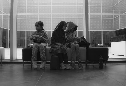 Black and white photo of three people sitting on a bench