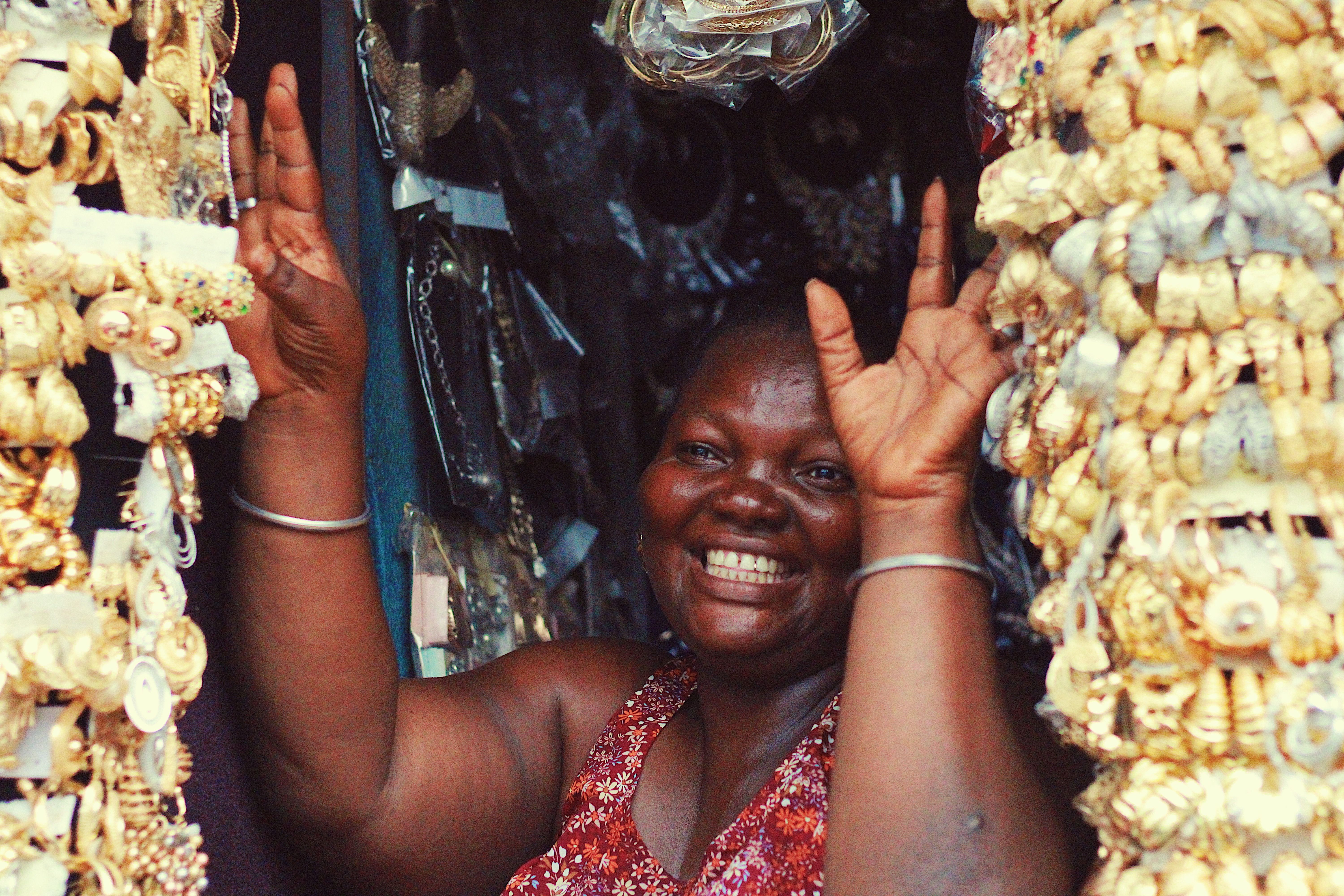 Joyful woman surrounded by gold jewelry displays her happiness.