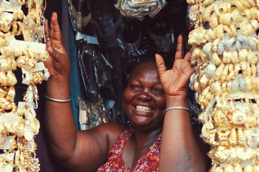 Joyful woman surrounded by gold jewelry displays her happiness.