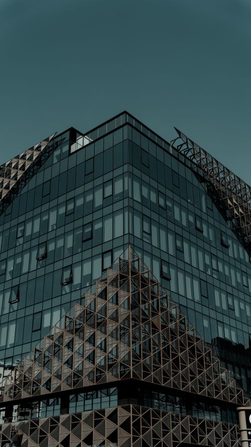 Free Sharp corner view of a contemporary glass office building with geometric patterns. Stock Photo
