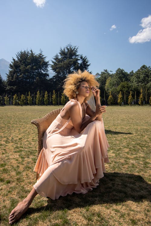 Woman in Dress Sitting on Grassland
