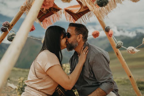 A couple kissing under a tent in the mountains