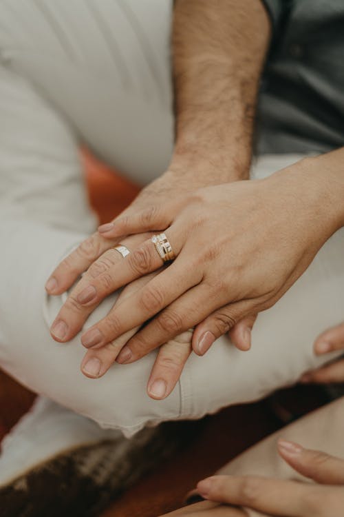 A close up of a man and woman holding hands