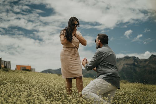 A man proposing to a woman in a field