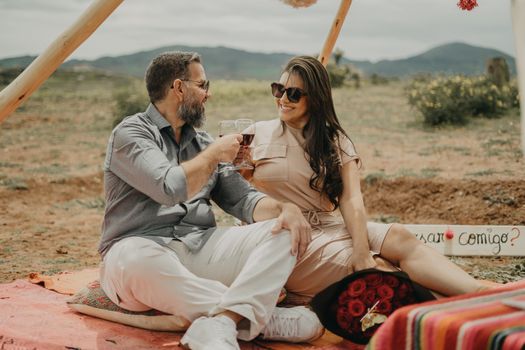Couple enjoying a romantic picnic in Maras, Peru with wine and roses.