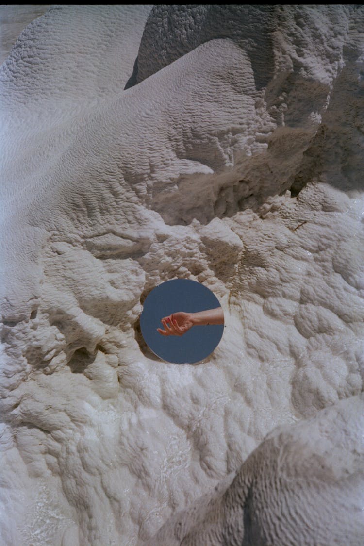 Hand Reflection In Mirror On Rocks