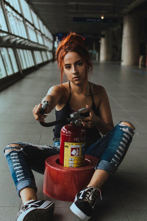 Free Woman Holding Red and Black Fire Extinguisher Stock Photo