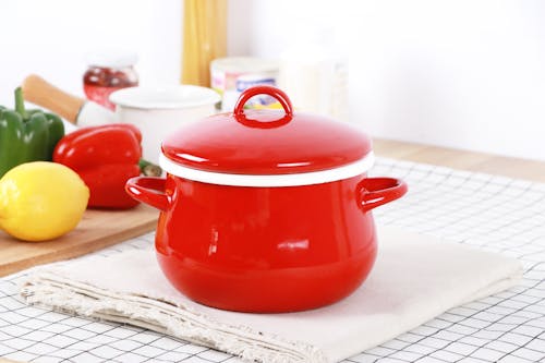 A red pot with a lid on top of a table