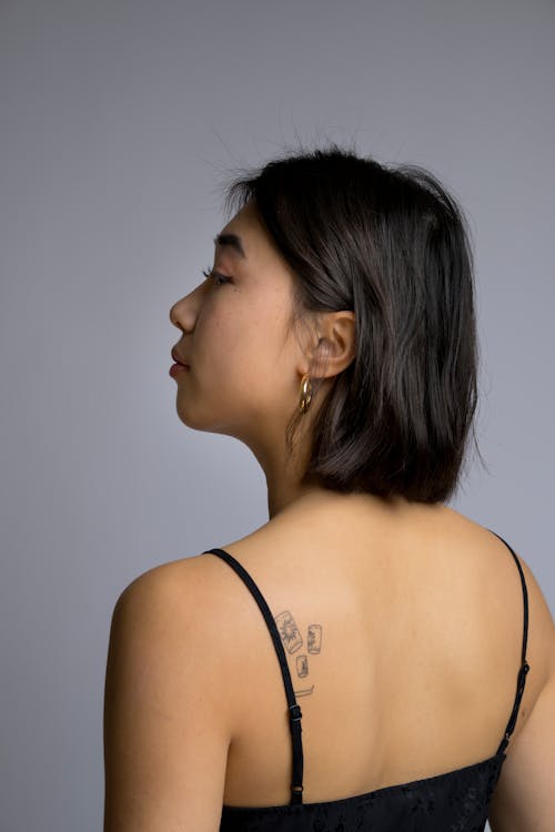Profile of an Asian Woman with Handpoke Tattoos on her Back