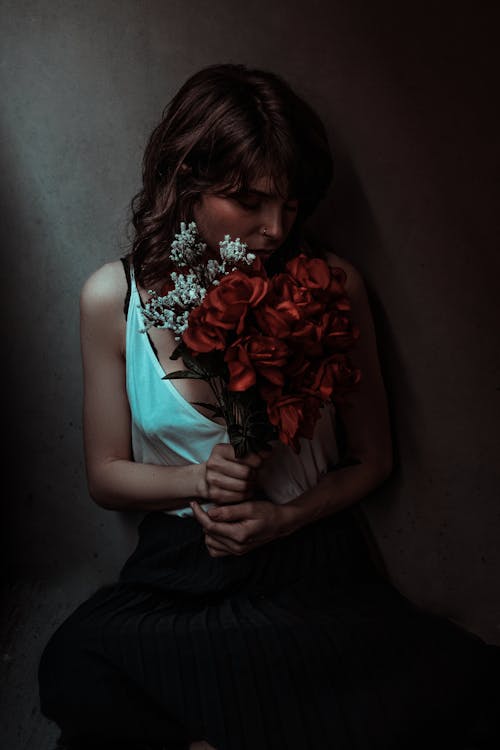 Woman Sitting with Bouquet of Red Roses