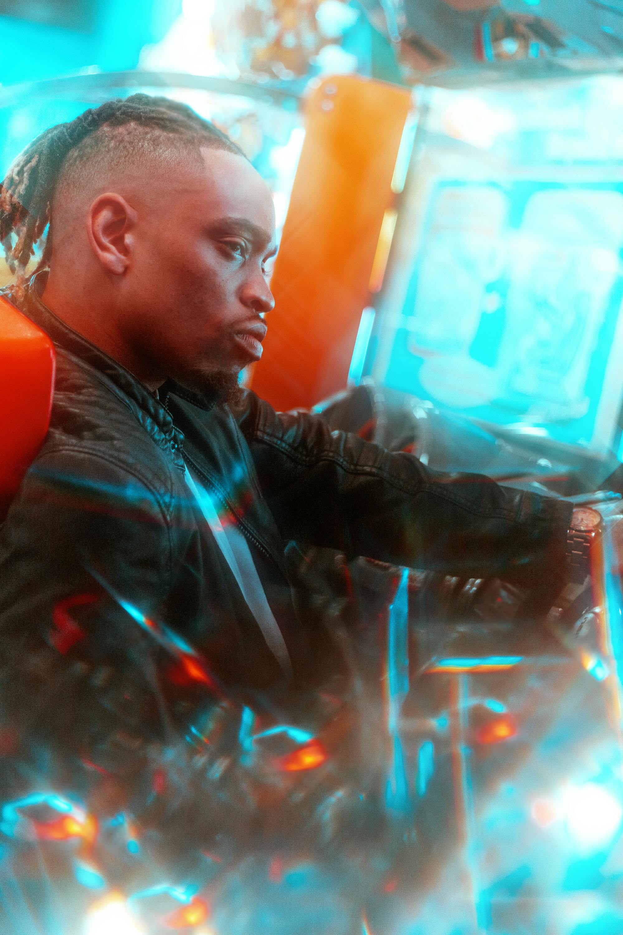 Stylish portrait of a man in a leather jacket under vibrant neon lights.