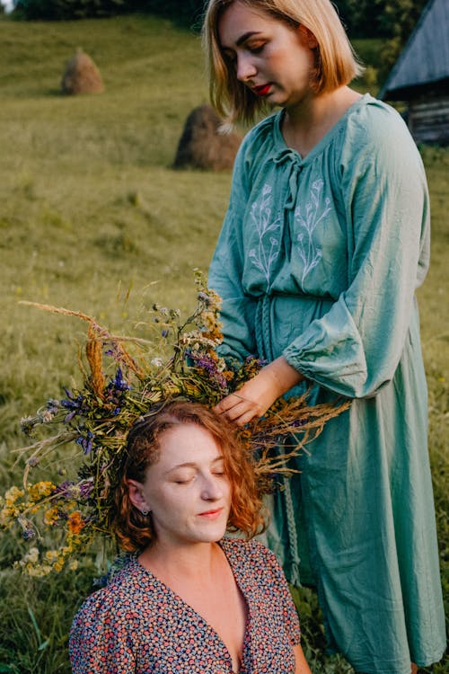 Two women are standing in a field with flowers