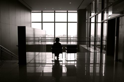 Free Black and white photo of a child sitting alone in a modern building in Tokyo. Stock Photo