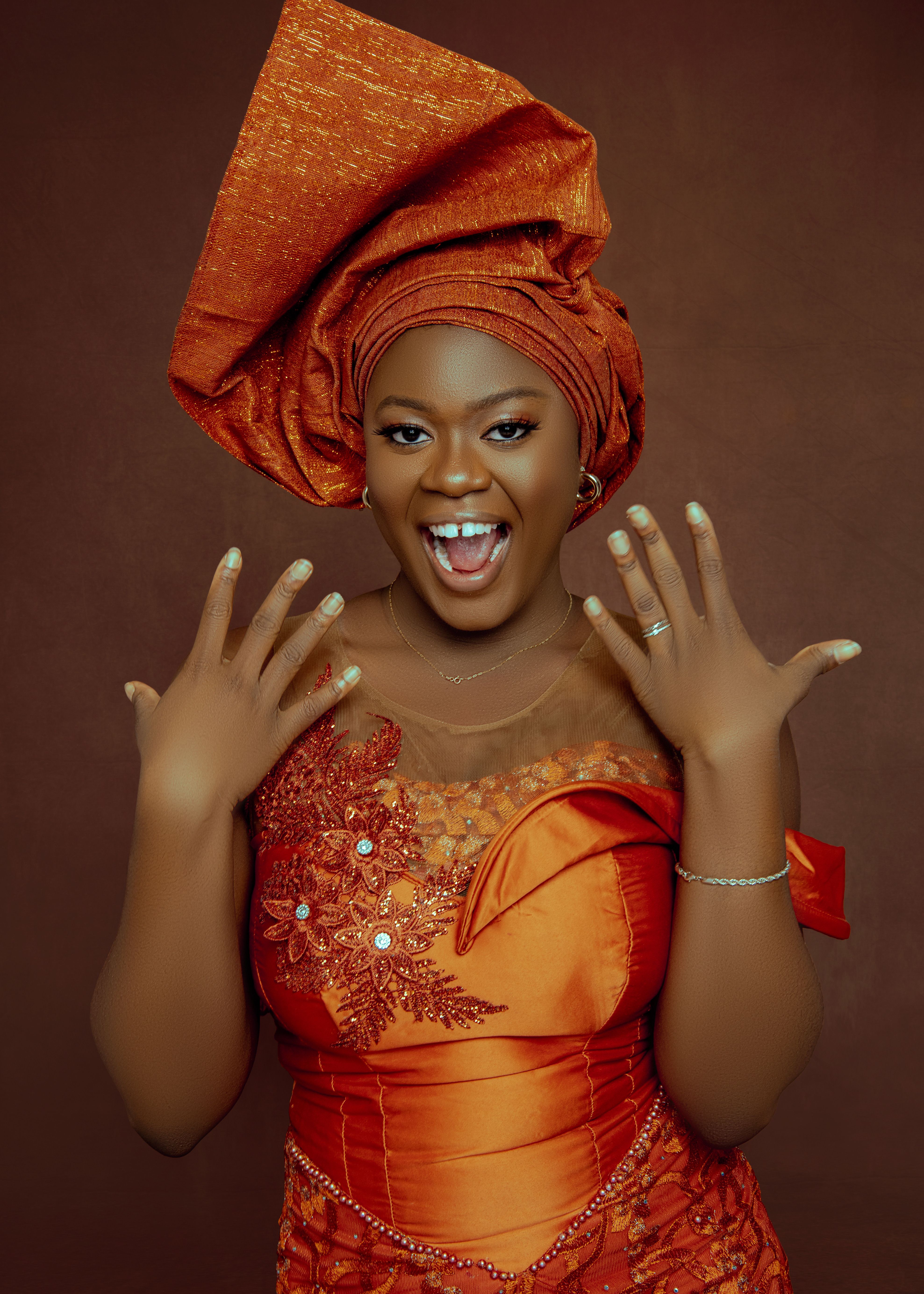 Exciting portrait of a woman in vibrant traditional African attire, expressing joy and elegance.