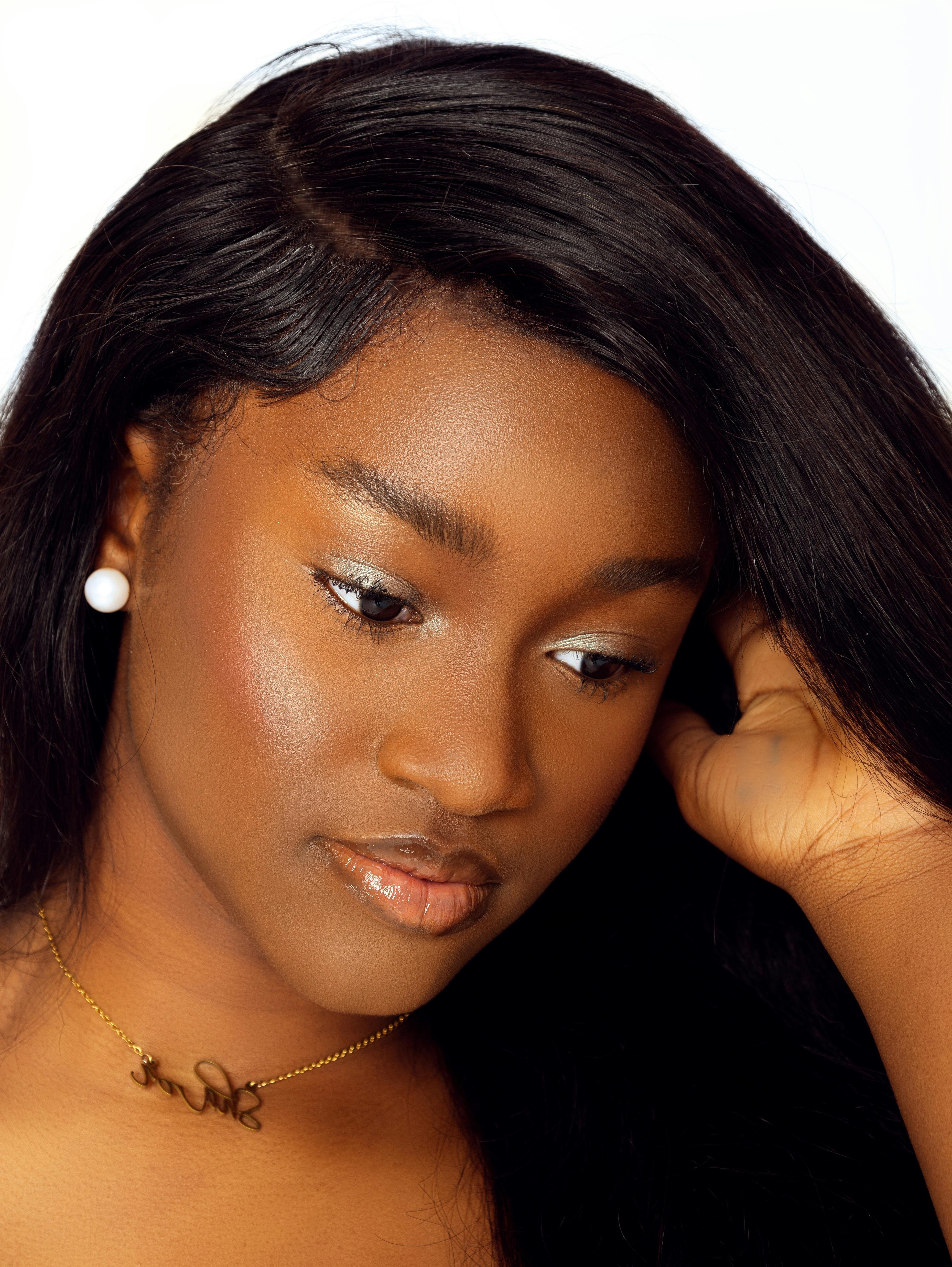 Studio portrait of a woman with long hair and gold necklace, showcasing elegance and style.