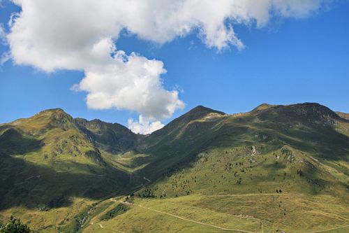 Free Explore the breathtaking scenery of rolling hills and blue skies in this captivating mountain landscape. Stock Photo