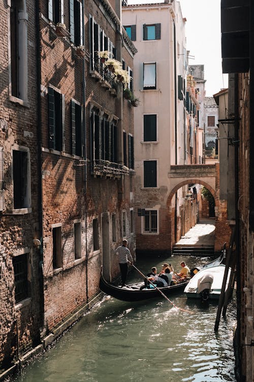 A gondola is floating down a narrow canal