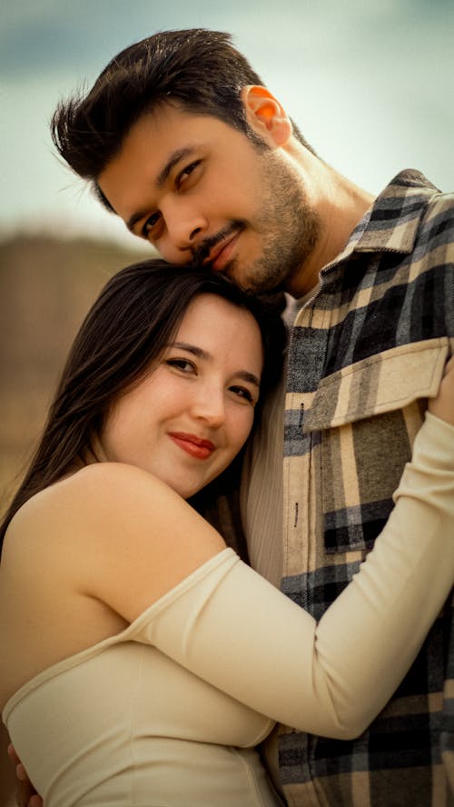 A young couple posing for a photo in front of a mountain